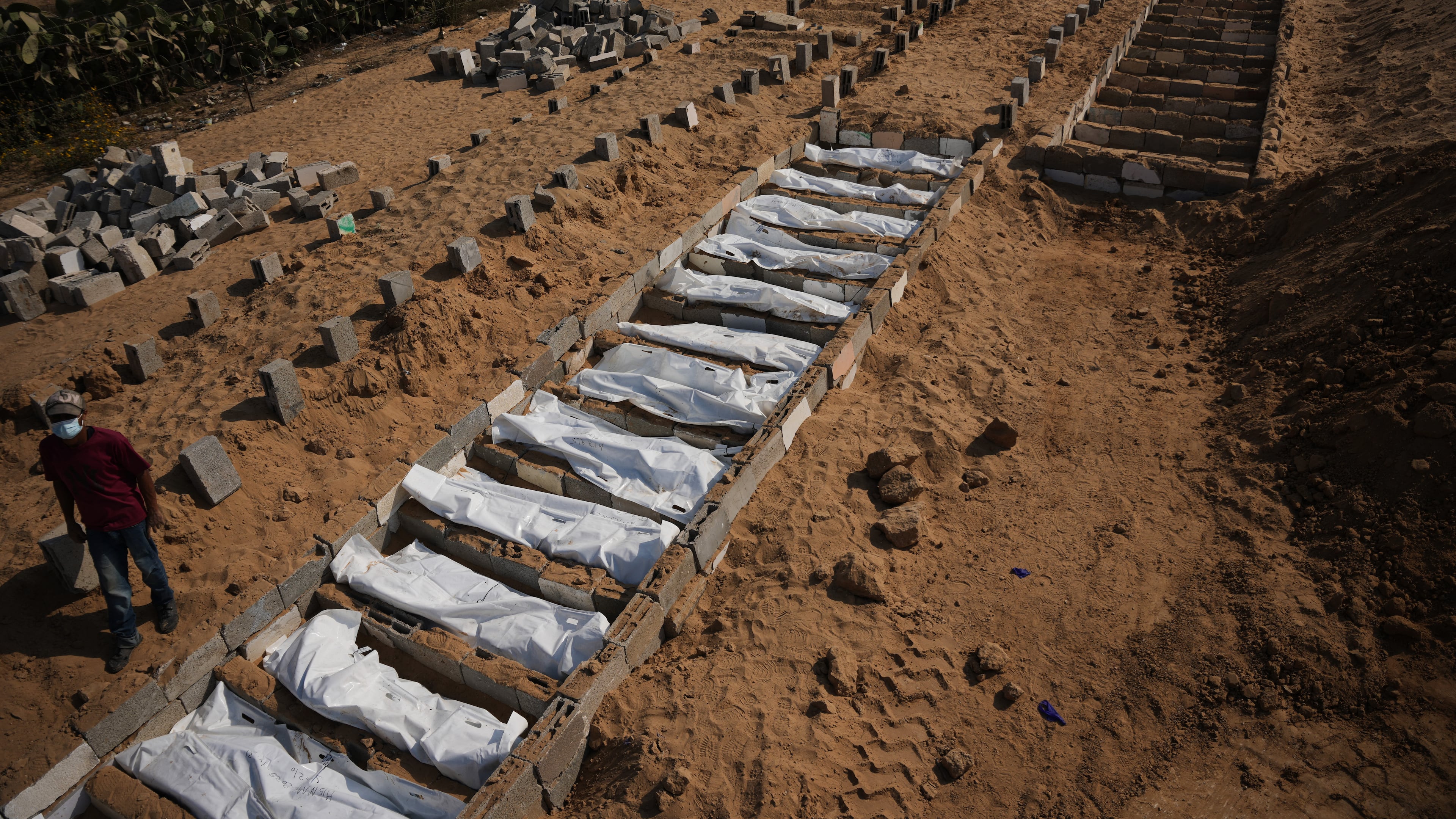 Bodies of unidentified Palestinians returned from Israel as part of the ceasefire deal are buried in a mass grave in Deir al-Balah, Gaza Strip, Wednesday, Nov. 5, 2025. (AP Photo/Abdel Kareem Hana)