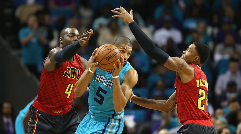 Nicolas Batum of the Hornets is trapped by Hawks’ Paul Millsap (4) and Kent Bazemore (24) during a game last season. (Photo by Streeter Lecka/Getty Images)