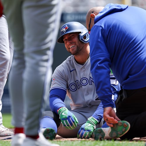 Toronto Blue Jays designated hitter George Springer is tended to after getting hit by a pitch during the third inning of a baseball game against the Minnesota Twins, Saturday, May 2, 2026, in Minneapolis. (AP Photo/Matt Krohn)