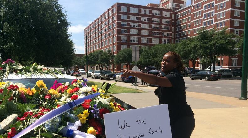 Dallas Police Det. Karen Lewis arranges flowers given in tribute to slain and injured officers. Photos: Jennifer Brett