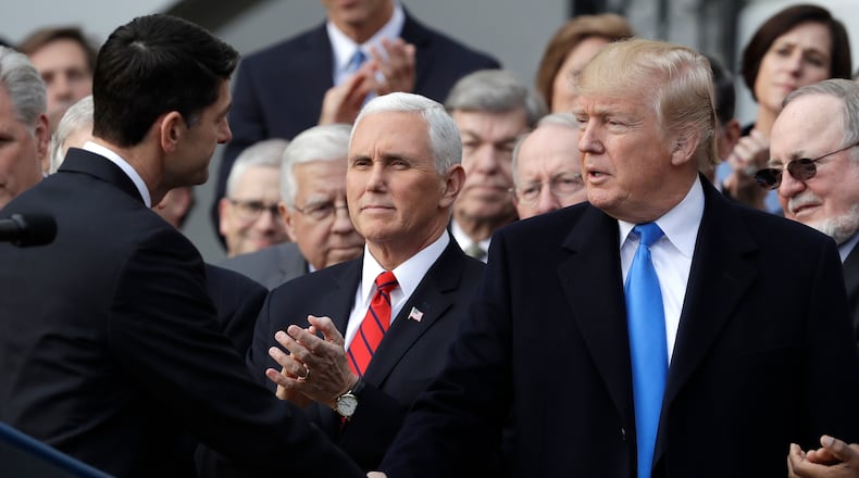 President Donald Trump shakes hands with House Speaker Paul Ryan of Wisconsin, as Vice President Mike Pence watches, during an event after the passage of the "Tax Cut and Jobs Act Bill" on the South Lawn of the White House, Wednesday, Dec. 20, 2017, in Washington. (AP Photo/Evan Vucci)