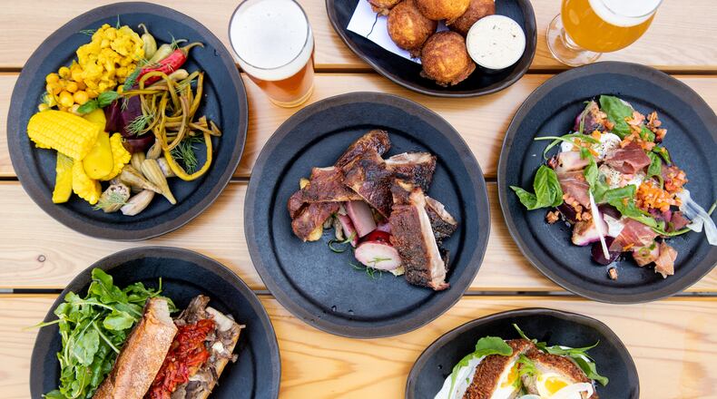 Biggerstaff Brewing Co. is a contemporary brewery restaurant on Edgewood Avenue in Old Fourth Ward. What you'll find includes (from left, top row) a pickles snack with seasonal vegetables, Honey Butter Ribs, Cornbread Bites, Warm Burrata, (from left, bottom row) Smoked Brisket Sandwich and Atlanta Egg. (Mia Yakel for The Atlanta Journal-Constitution)