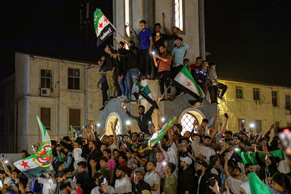 Syrians celebrate after U.S. President Donald Trump announced plans during his visit to Saudi Arabia to ease sanctions on Syria and normalize relations with its new government, in Homs, Syria, late Tuesday, May 13, 2025.(AP Photo/Omar Albam)