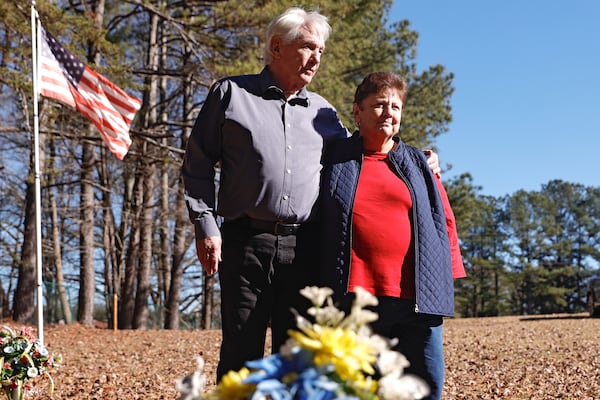 Gene Odom and Wanda Keith stand at the gravesite of their uncle, Herman Wilder, in Gainesville. (Natrice Miller/AJC)