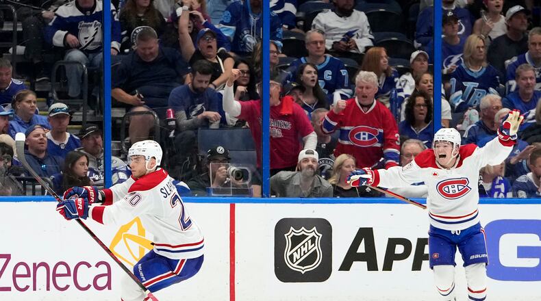 Montréal Canadiens left wing Juraj Slafkovský (20) celebrates his goal with right wing Cole Caufield against the Tampa Bay Lightning during overtime in Game 1 of an NHL hockey Stanley Cup first-round playoff series, Sunday, April 19, 2026, in Tampa, Fla. (AP Photo/Chris O'Meara)