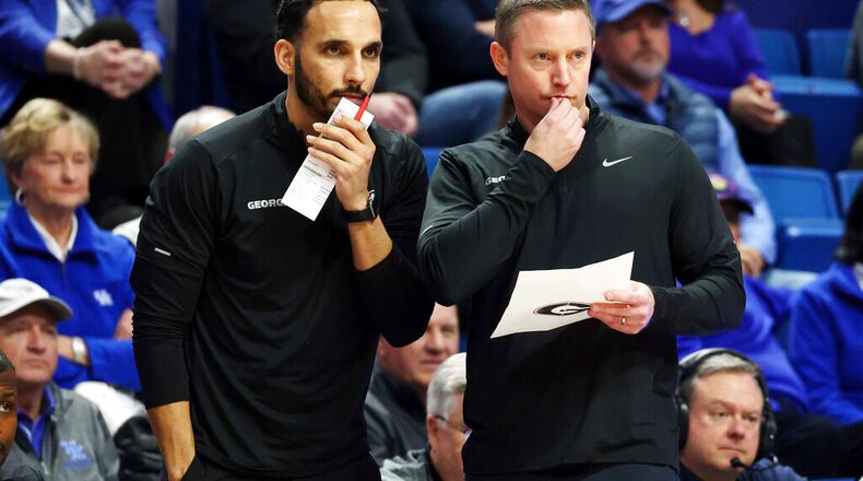 Georgia's assistant coach Erik Pastrana, left, and head coach Mike White study the action during the first half of an NCAA college basketball game against Kentucky in Lexington, Ky., Tuesday, Jan. 17, 2023. (AP Photo/James Crisp)