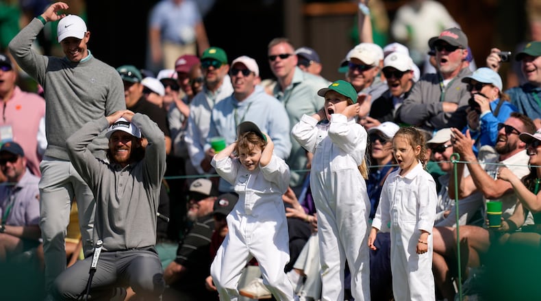 Rory McIlroy, from left, and Tommy Fleetwood react to a shot with his son, Franklin, Shane Lowry's daughter, Iris, and Rory McIlroy's daughter, Poppy, on the seventh hole during par-3 contest ahead of the Masters golf tournament at the Augusta National Golf Club, Wednesday, April 8, 2026, in Augusta, Ga. (AP Photo/Eric Gay)