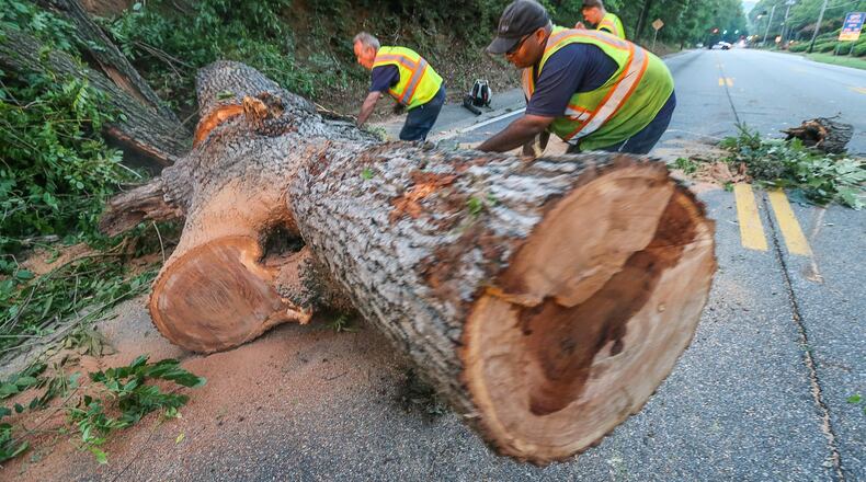 Crews worked Wed., June 17, 2015, to clear a tree from Ga. 9 in Roswell. JOHN SPINK / JSPINK@AJC.COM