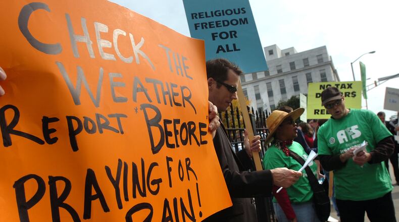 Protesters from Atlanta Freethought Society hold signs before "Prayer Service for Rain" starts outside The Georgia State Capitol in Atlanta. Gov. Sonny Perdue holds a prayer service for rain Tuesday at 11:45 a.m. Tuesday, November 13, 2007. (HYOSUB SHIN / Staff)