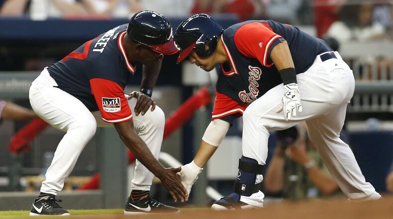 Catcher Kurt Suzuki (right) of the Braves is congratulated by third base coach Ron Washington after Suzuki’s home run in the second inning. (Photo by Mike Zarrilli/Getty Images)