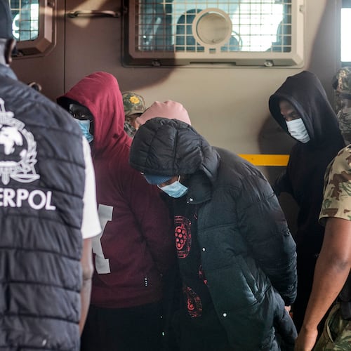 Members of the elite tactical police unit escort six Nigerians nationals being extradited to US for participating in romance scams, in Cape Town, South Africa, Friday, Sept. 11, 2026. (AP Photo)