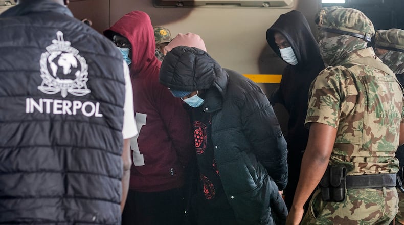 Members of the elite tactical police unit escort six Nigerians nationals being extradited to US for participating in romance scams, in Cape Town, South Africa, Friday, Sept. 11, 2026. (AP Photo)