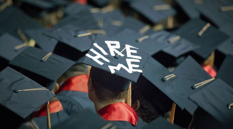 A college student puts a job plea on his graduation cap. (AJC file.)