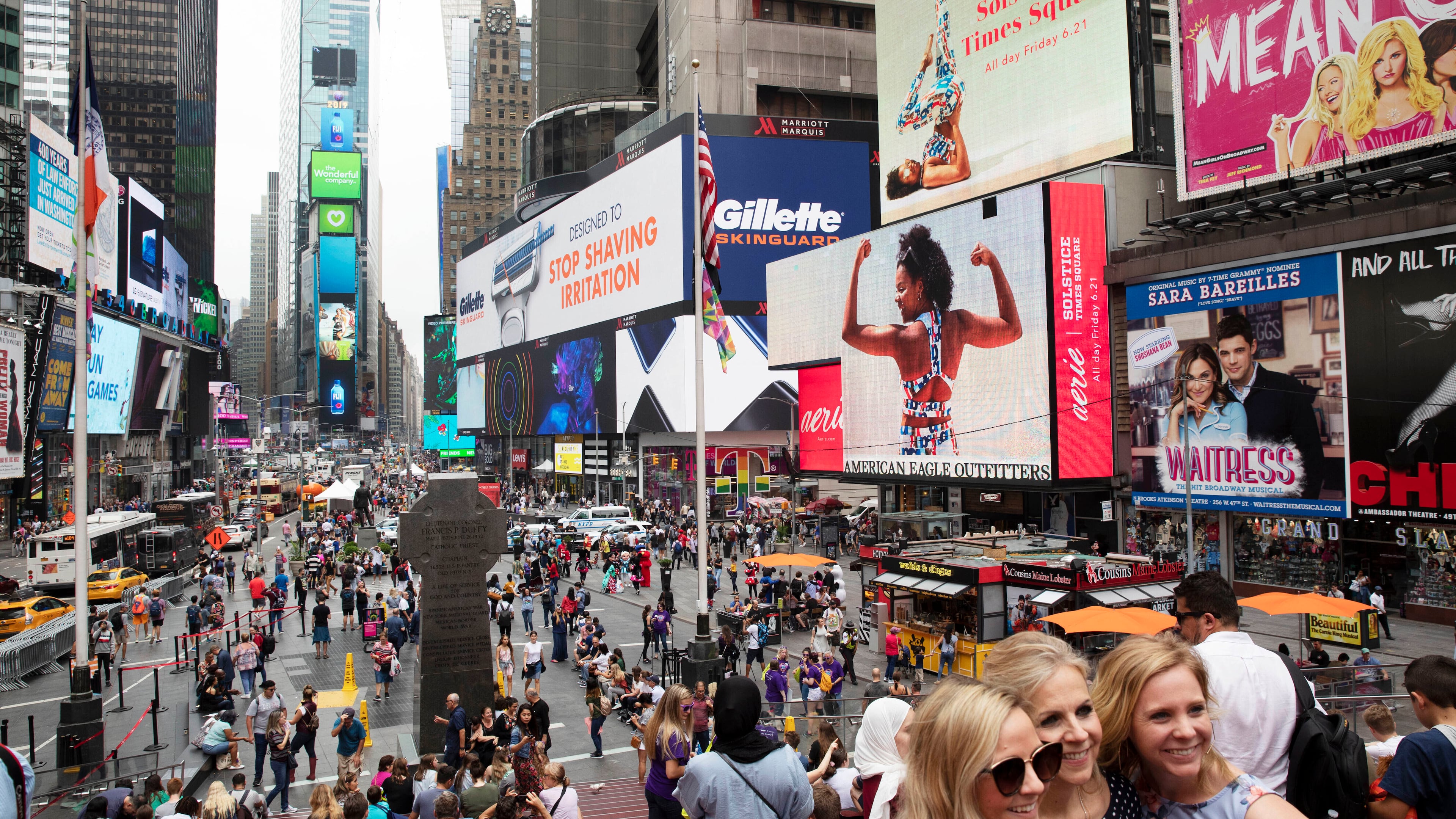 FILE - In this June 20, 2019, file photo, tourists visit Times Square in New York. (AP Photo/Mark Lennihan, File)