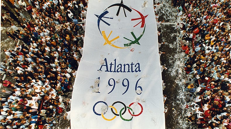 Atlanta, GA - Olympics parade - An Atlanta 1996 Olympic banner makes it's way north along Peachtree Street in downtown Atlanta Monday, September 24, 1990 celebrating Atlanta's having been awarded the 1996 Summer Olympics. (JOEY IVANSCO/ AJC staff)