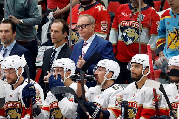 Florida Panthers head coach Paul Maurice, back center, waits for the results of his coaches challenge during the second period of Game 2 of the NHL hockey Stanley Cup Eastern Conference finals against the Carolina Hurricanes in Raleigh, N.C., Thursday, May 22, 2025. (AP Photo/Karl DeBlaker)
