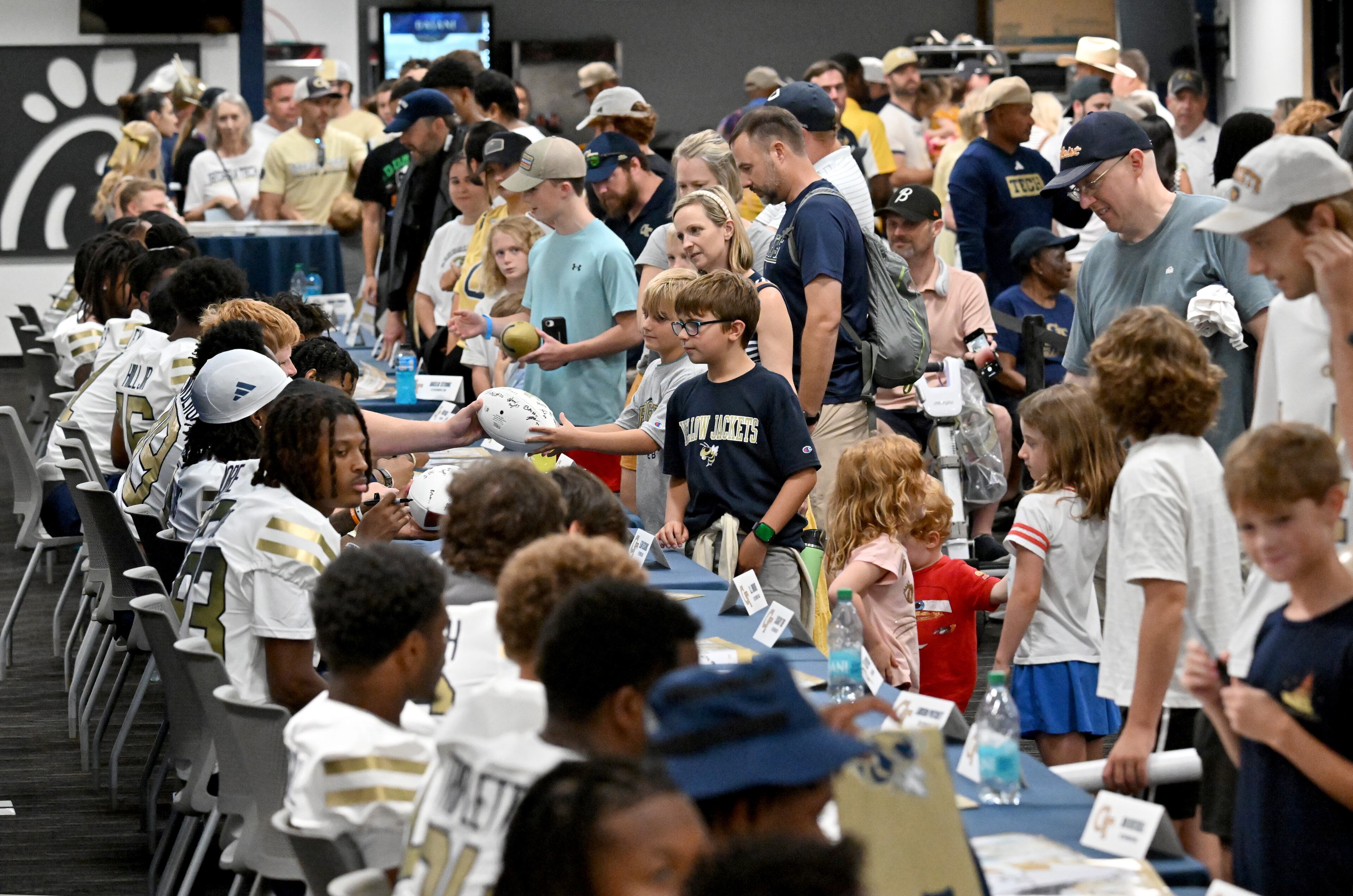 Georgia Tech football players sign autographs for event attendees during the annual “First Saturday on The Flats” at Bobby Dodd Stadium, Saturday, August 2, 2025, in Atlanta. The Flats provides Tech fans with the opportunity to engage with their favorite Yellow Jackets ahead of the upcoming 2025 season. The event offers a variety of entertaining activities for the whole family, including a DJ, autograph opportunities, tailgate games and interactive experiences right on the field at Bobby Dodd Stadium. (Hyosub Shin / AJC)