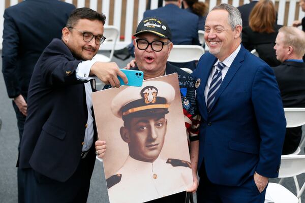 FILE - David Campos, left, vice chair of the California Democratic Party, takes a selfie with Nicole Murray-Ramirez, center, an LGBT activist, holding a photo of Harvey Milk, and Bevan Dufty, right, director of the San Francisco Bay area rapid transit district, prior to the launching of the USNS Harvey Milk, a fleet replenishment oiler ship named after the first openly gay elected official, Saturday, Nov. 6, 2021 in San Diego. (AP Photo/Alex Gallardo, File)