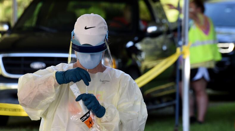 Cathy Webb, LPN, secures a COVID-19 test outside Glynn County Health Department in Brunswick. Ryon Horne/RHORNE@AJC.COM