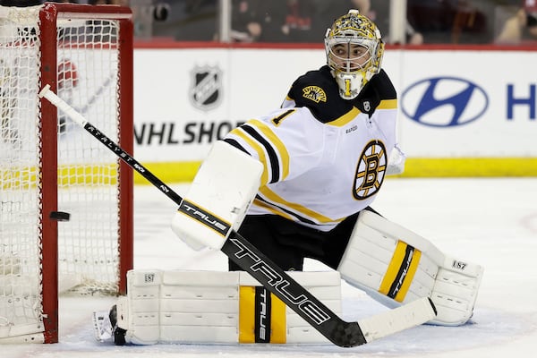 Boston Bruins goaltender Jeremy Swayman watches a shot go wide of the net in the second period of an NHL hockey game against the New Jersey Devils, Tuesday, April 8, 2025, in Newark, N.J. (AP Photo/Adam Hunger)