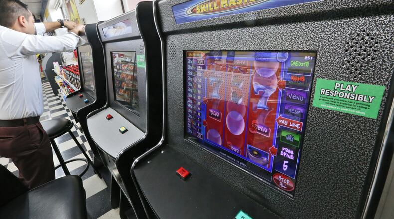A technician opens a coin-operated amusement machine at a Duluth gas station. BOB ANDRES / BANDRES@AJC.COM