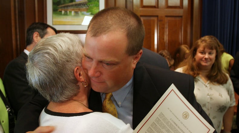 ATLANTA, GA -- Former Olympic security guard Richard Jewell hugs his mother Barbara as his wife Dana , at right, looks on Tuesday afternoon, August 1, 2006 after he received a commendation from Gov. Sonny Perdue for his service during the Olympics. (BEN GRAY/AJC staff)