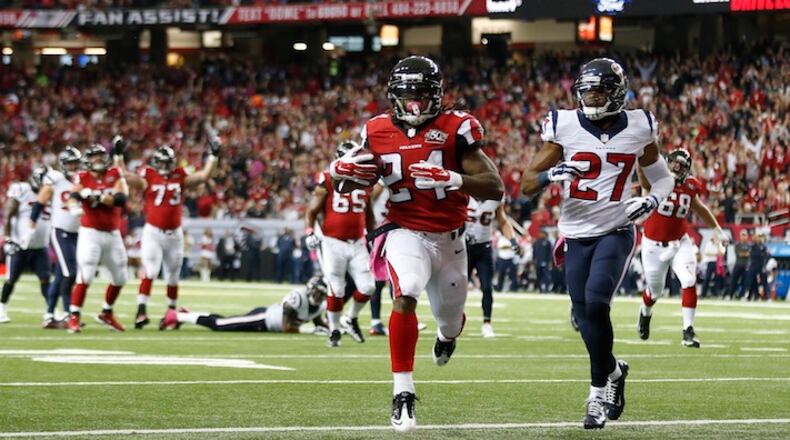 Atlanta Falcons running back Devonta Freeman (24) runs into the end zone against Houston Texans strong safety Quintin Demps (27) for a touchdown during the first half of an NFL football game, Sunday, Oct. 4, 2015, in Atlanta. (AP Photo/John Bazemore)