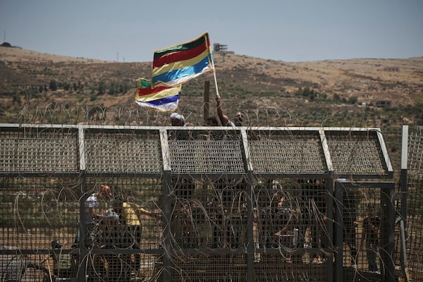 Syrian Druze protest near the Israeli-Syrian border, as seen from the town of Majdal Shams in the Israeli-controlled Golan Heights, Wednesday, July 16, 2025, amid the ongoing clashes between Syrian government forces and Druze armed groups in the southern Syrian city of Sweida. (AP Photo/Leo Correa)