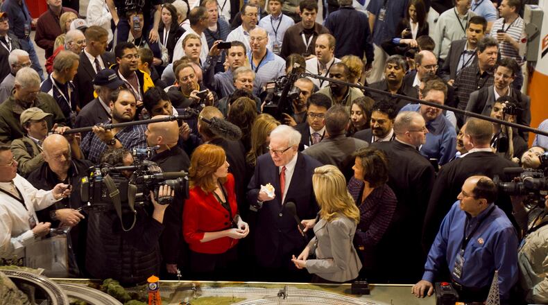 FILE - Berkshire Hathaway Chairman and CEO Warren Buffett, center, is surrounded by journalists and shareholders as he stops by a model railroad while touring the exhibit floor where Berkshire subsidiaries display their products in Omaha, Neb., April 30, 2011, prior to presiding over the annual Berkshire Hathaway shareholders meeting. (AP Photo/Nati Harnik, File)