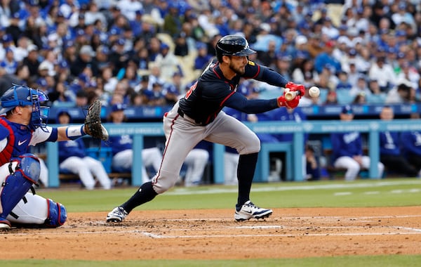 Atlanta Braves' Eli White lays down a bunt single against the Los Angeles Dodgers during the second inning of a baseball game Wednesday, April 2, 2025, in Los Angeles. (AP Photo/Kevork Djansezian)