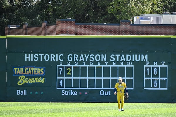 Savannah Bananas number 5 DR Meadows walks in front of the historic scoreboard during the Savannah Bananas and the Texas Tailgaters preseason game on Feb. 22 at Grayson Stadium in Savannah, Ga. (Sarah Peacock for the AJC)