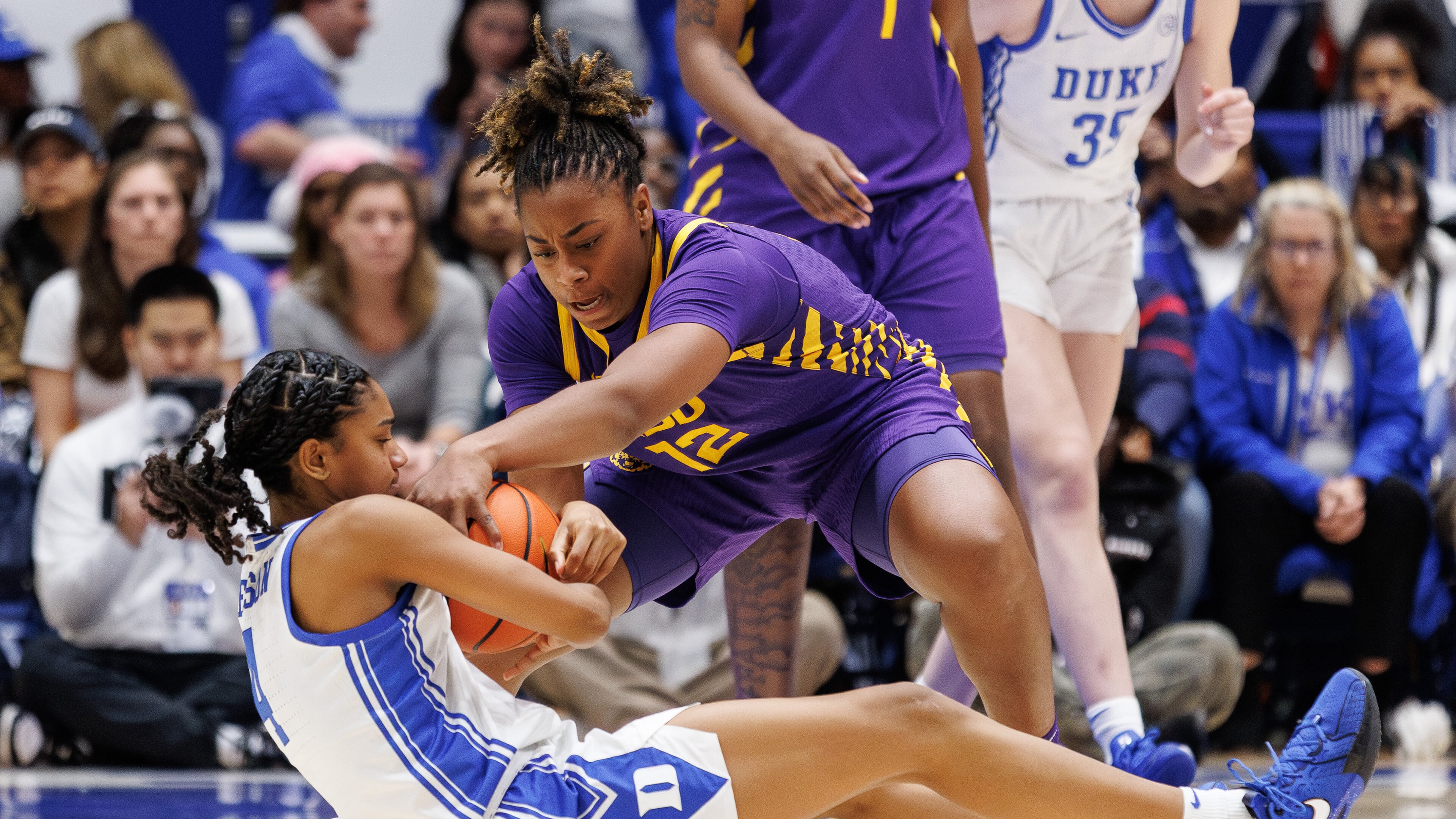 LSU's Mikaylah Williams (12) and Duke's Riley Nelson (4) battle for a loose ball during the second half of an NCAA college basketball game in Durham, N.C., Thursday, Dec. 4, 2025. (AP Photo/Ben McKeown)