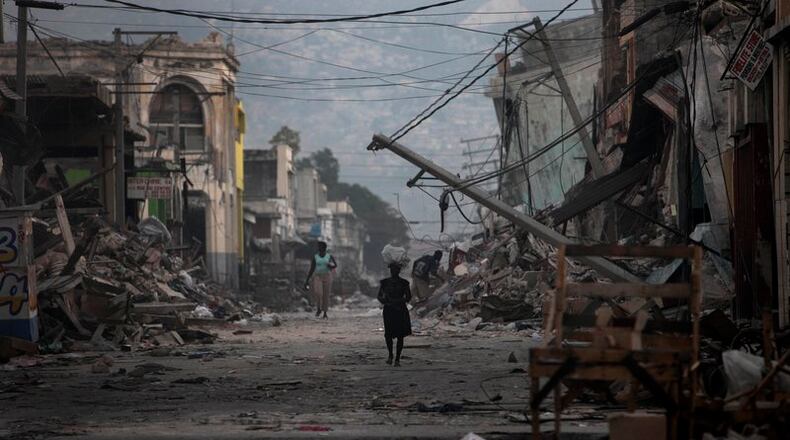 A woman walks down a devastated street in Port-au-Prince, Haiti, in the wake of a 2010 earthquake. (AP)