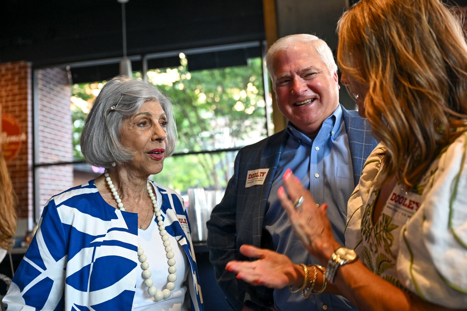 Barbara Dooley, Derek Dooley’s mother (left), talks with Clay and Stephanie Powell at Georgia GOP gubernatorial candidate Derek Dooley election night party at Park Bench at the Battery during the 2026 Georgia primary elections Tuesday, May 19, 2026, in Atlanta. (Daniel Varnado for the AJC)
