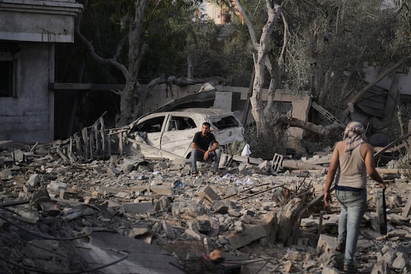 Palestinians inspect the rubble of the Al-Aimawi family's home, destroyed by Israeli airstrikes in Al-Zawaideh, Gaza Strip, on Tuesday, July 1, 2025. (AP Photo/Abdel Kareem Hana)