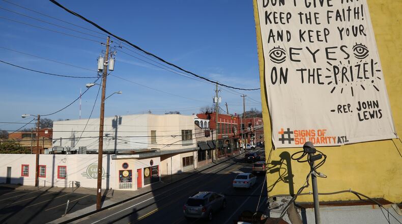 A quote from Congressman John Lewis is printed on a banner hanging on Edgewood Avenue in the Martin Luther King district, as part of the Signs of Solidarity effort. Artist: Catlanta; Photo: Brandon English