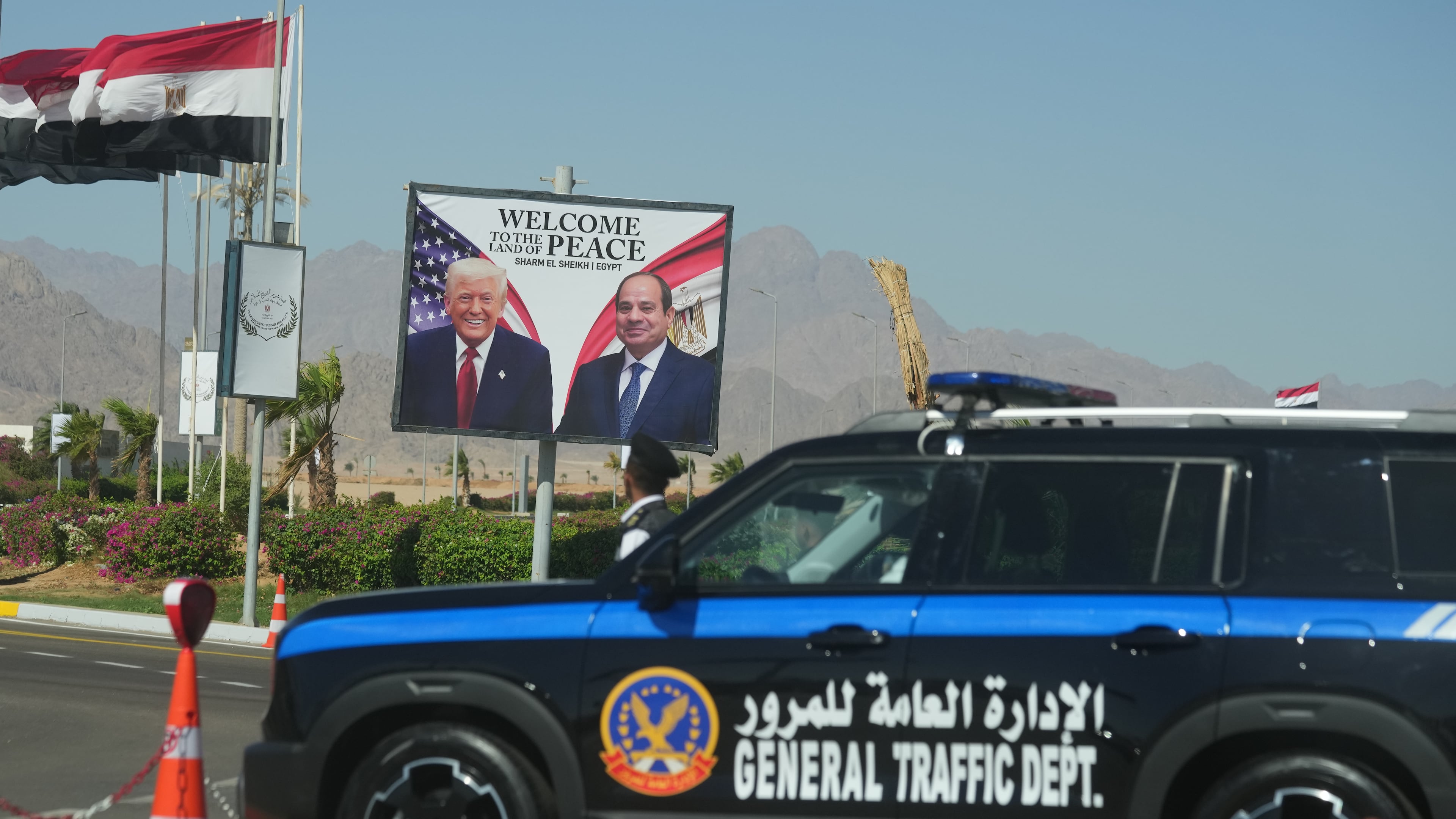 A police vehicle in front of a poster showing Egyptian President Abdel-Fattah el-Sissi and U.S. President Donald Trump at the Red Sea city of Sharm el-Sheikh, Egypt, Monday, Oct. 13, 2025. (AP Photo/Amr Nabil)