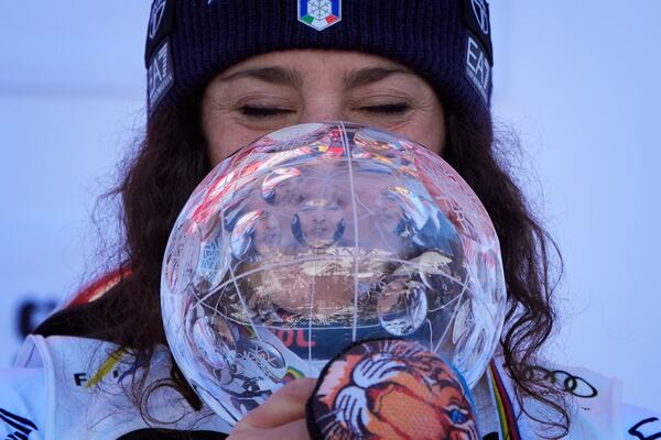 Italy's Federica Brignone is reflected in the trophy after winning the women's giant slalom season championship at the World Cup Finals, Tuesday, March 25, 2025, in Sun Valley, Idaho. (AP Photo/John Locher)