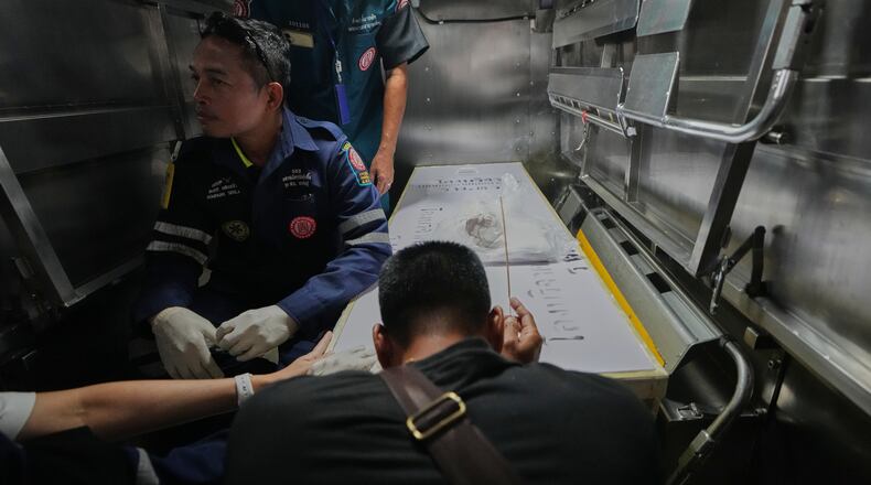 A relative of a victim in a music bar fire pays respect to the victim's body at a police hospital in Bangkok, Thailand, Tuesday, July 14, 2026. (AP Photo/Sakchai Lalit)