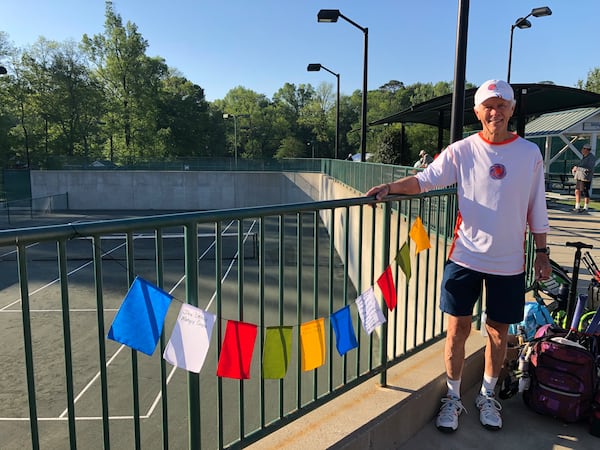 Keith Richardson, a former world top-100 tennis player, stands with his Remembrance Flags at the 2023 Atlanta Senior Invitational. He returned with a much longer string this year. Remembrance Flags display the names of players or coaches who have passed away or those who are facing serious challenges that prevent them from attending the tournament.