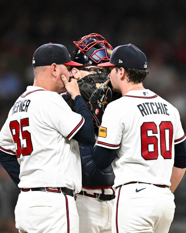 Braves pitching coach Jeremy Hefner (clockwise from left), catcher Sean Murphy and pitcher JR Ritchie meet on the mound during their game against the Reds on Tuesday, Sept. 22, 2026, at Truist Park in Atlanta. (Daniel Varnado for the AJC)