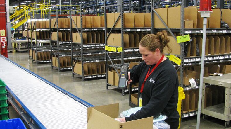Worker packing goods to be shipped from Radial's Locust Grove distribution center. The facility is part of Radial's network of centers. The Belgian-owned company is ramping up for the seasonal rush.