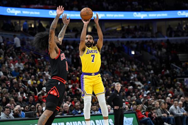 Los Angeles Lakers' Gabe Vincent (7) goes up for a shot against Chicago Bulls' Coby White (0) during the first half of an NBA basketball game Thursday, March 27, 2025, in Chicago. (AP Photo/Paul Beaty)