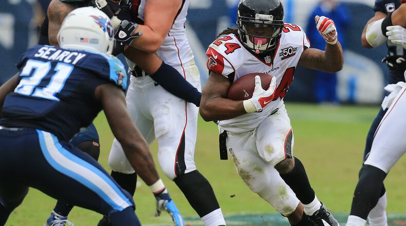 102515 NASHVILLE: -- Falcons running back Devonta Freeman finds some running room against Titans safety Da’ Norris Searcy during the first half in a football game on Sunday, Oct. 25, 2015, in Nashville. Curtis Compton / ccompton@ajc.com