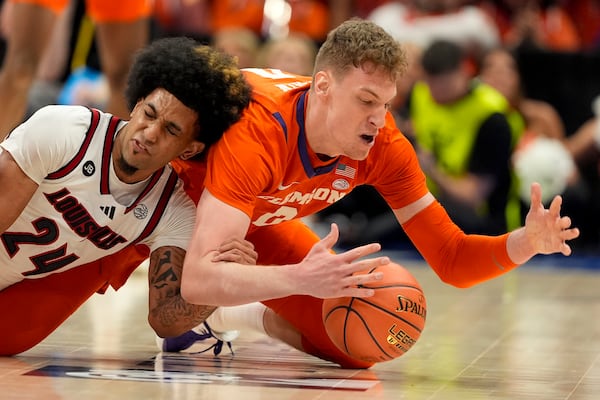 FILE - Louisville guard Chucky Hepburn and Clemson center Viktor Lakhin vie for a loose ball during the second half of an NCAA college basketball game in the semifinals of the Atlantic Coast Conference tournament, Friday, March 14, 2025, in Charlotte, N.C. (AP Photo/Chris Carlson, File)