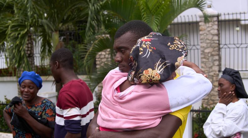 Relatives of a victim of a deadly stampede embrace each other in Milot, Haiti, Sunday, April 12, 2026. (AP Photo/Ketlain Difficile)
