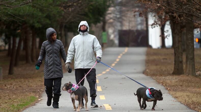 Ramona and Paul Hoyt walk their dogs on the Beltline near the Carter Center Saturday, January 13, 2018.