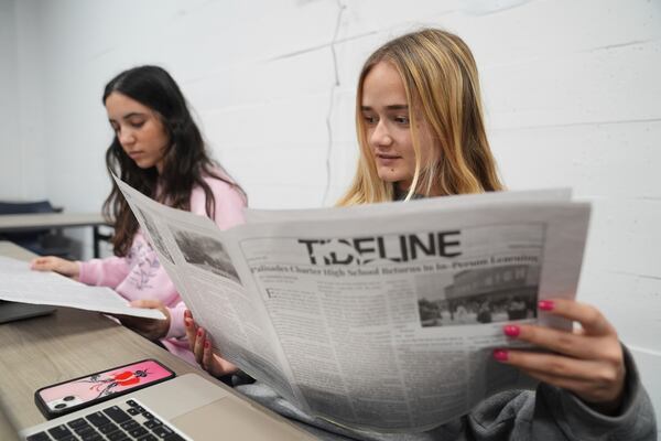 Staff members of Tideline, Palisades High School's newspaper, Sophia Masserat, left, and Eve Keller read a copy of the publication, freshly delivered from Philadelphia, Wednesday, May 14, 2025, in Santa Monica, Calif. (AP Photo/Marcio Jose Sanchez)