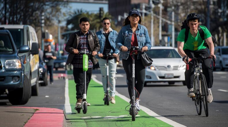 People ride LimeBike, left, and Bird electric scooters on the Embarcadero in San Francisco on April 13, 2018. MUST CREDIT: David Paul Morris/Bloomberg Photo by: David Paul Morris - Bloomberg