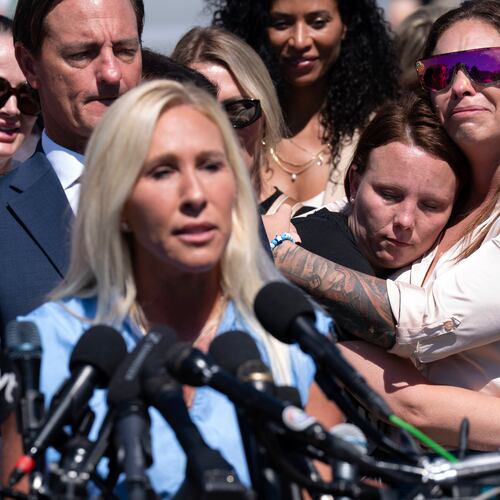 Jena-Lisa Jones (center) hugs Haley Robson (right) as Republican Rep. Marjorie Taylor Greene of Georgia addresses a news conference at the U.S. Capitol on Wednesday. (Jose Luis Magana/AP)